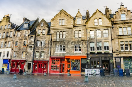 Постер Улочка с историческими домами и красочными витринами магазинов в Старом городе Эдинбурга (Шотландия)  