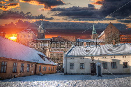 Картина Зимний пейзаж с видом на крепость Акерсхус и старинные домики на фоне закатного золотого неба 