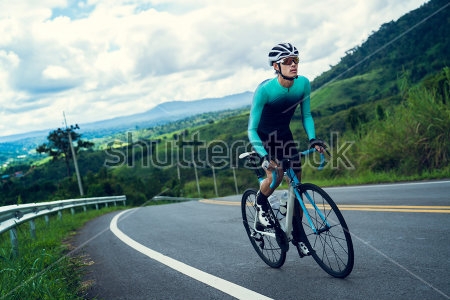 Картина Велосипедист едет в гору по красивой живописной дороге 