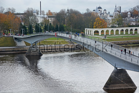Постер Живописный вид на исторический архитектурный ансамбль и пешеходный мост в Новгороде  