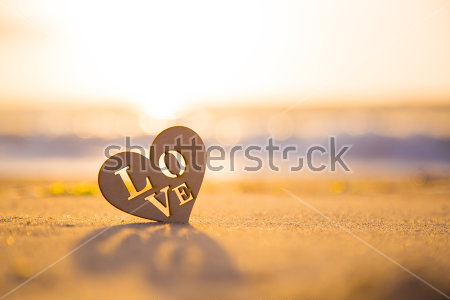 Картина Деревянное сердечко с надписью Love на песчаном побережье в лучах рассвета 