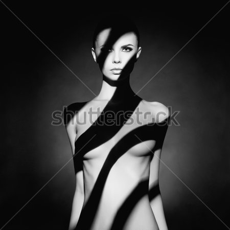 Постер Чёрно-белый портрет обнажённой девушки в красивом мягком освещении с чёрными полосами теней  