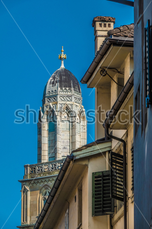 Картина Вид на башню собора Гросмюнстер в необычном красивом ракурсе с крышами и ставнями жилого дома  