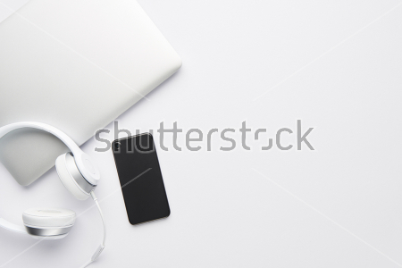 Картина Чёрно-белый натюрморт с белым ноутбуком и наушниками, и чёрным телефоном на белом фоне 