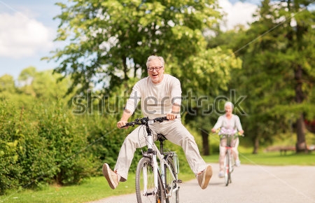 Картина Радостная пара в возрасте на велосипедной прогулке в зелёном парке 