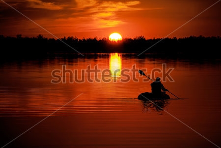Картина Человек на каяке плавает по озеру на закате 
