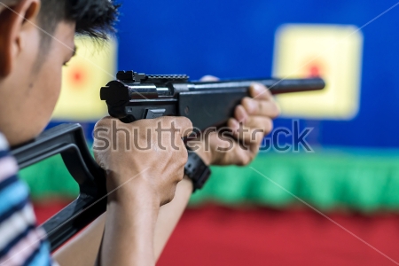 Картина Молодой человек с ружьём целится в мишень на стрельбище 