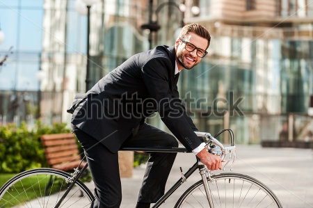 Картина Молодой мужчина в деловом костюме на спортивном велосипеде в городе 