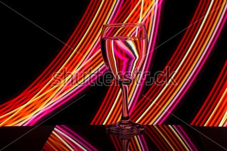 Постер Бокал вина на чёрном фоне с полосами разноцветного неонового света  