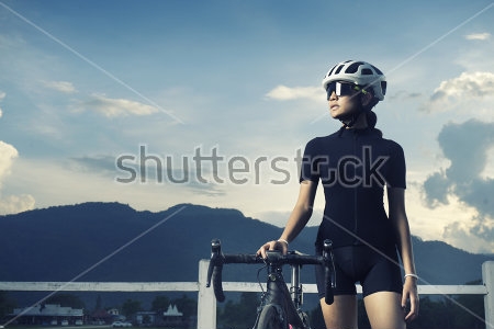 Картина Девушка велогонщица в шлеме и очках стоит с велосипедом на фоне горного пейзажа 