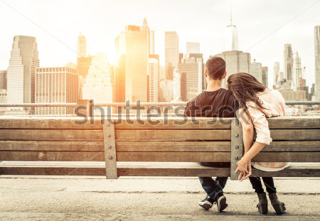 Картина Влюблённые на скамейке на фоне небоскрёбов большого города в лучах заката 
