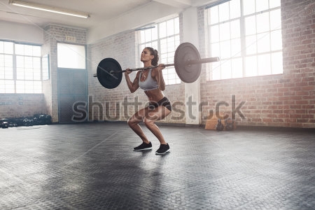 Картина Девушка выполняет силовое упражнение со штангой 