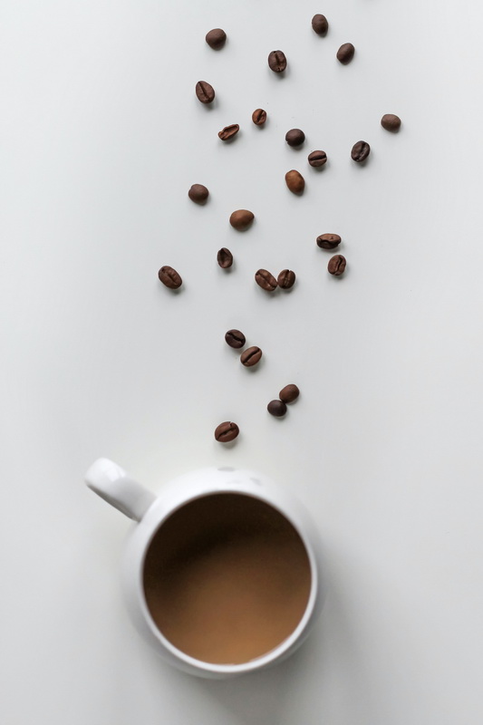Чашка заварного кофе и сердце, сделанное из кофейных зерен