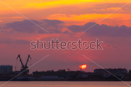 Картина Урбанистический пейзаж с заходящим солнцем и красивым закатным небом над портом и жилыми домами в Астрахани 